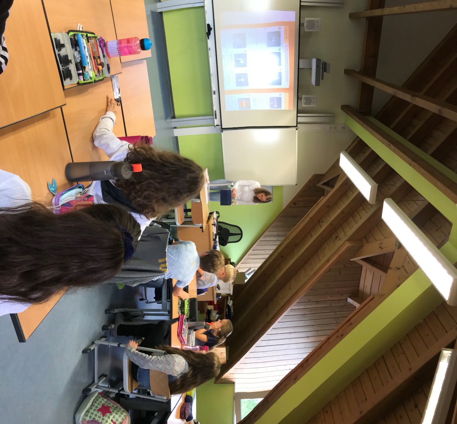 Bildunterschrift: SchülerInnen der 4. Klasse mit ihrer Klassenlehrerin Frau Rebecca Manz im Unterricht mit IPad und Whiteboard.